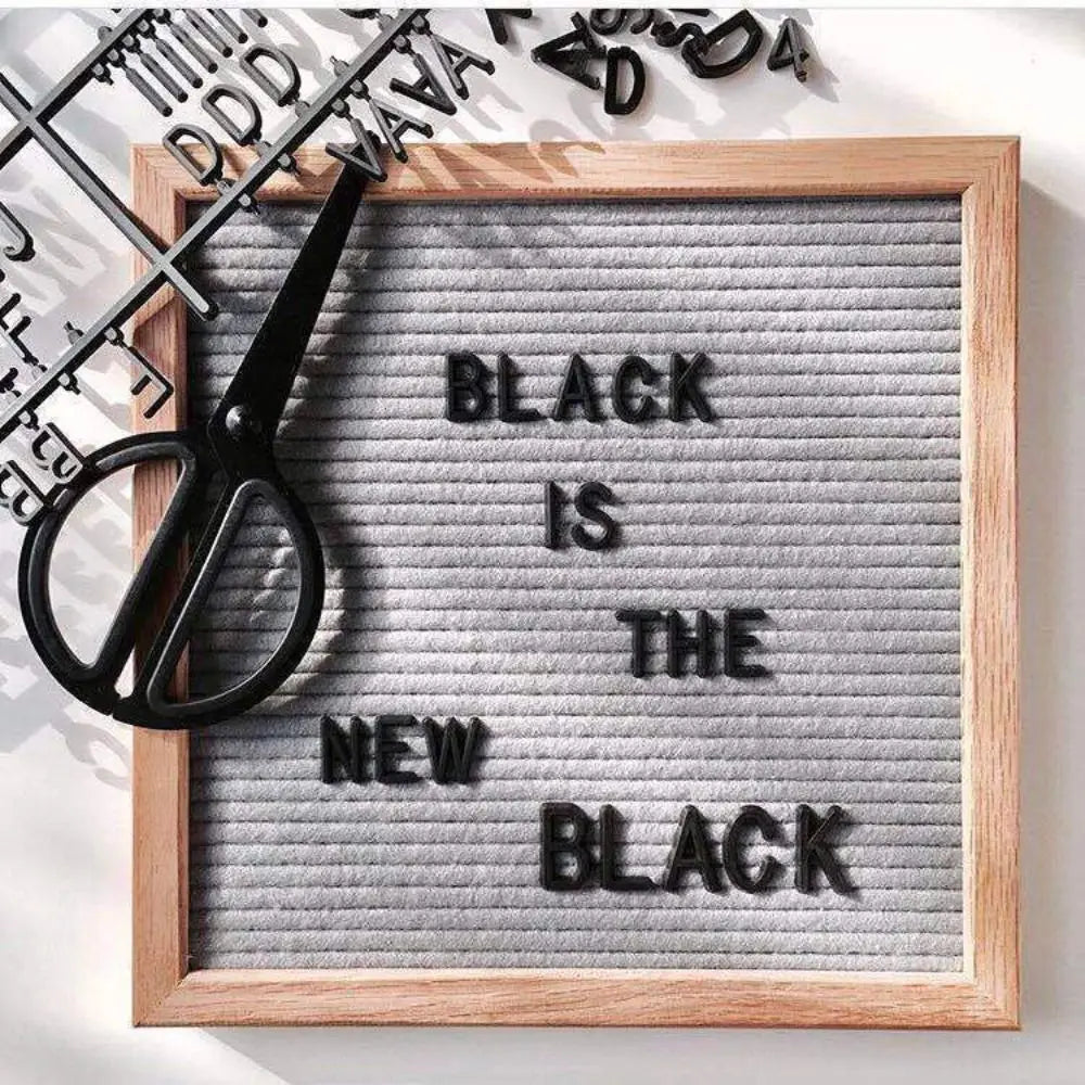 A wooden letter message board with a framed message that reads Black is the new black.