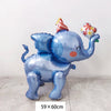 A blue foil balloon shaped like an elephant with a pink and orange conical hat.