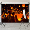 A banner featuring a dark night scene with glowing orange lanterns and two people looking at them.