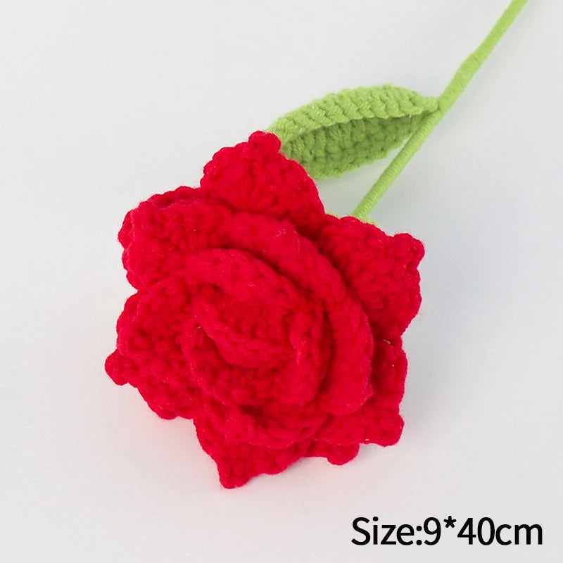 A handmade red crochet rose flower attached to a green stem, used for home decor or gifting.