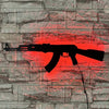 A silhouette of a gun-shaped light fixture is displayed on a textured stone wall with a red glow effect.