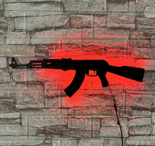 A silhouette of a gun-shaped light fixture is displayed on a textured stone wall with a red glow effect.