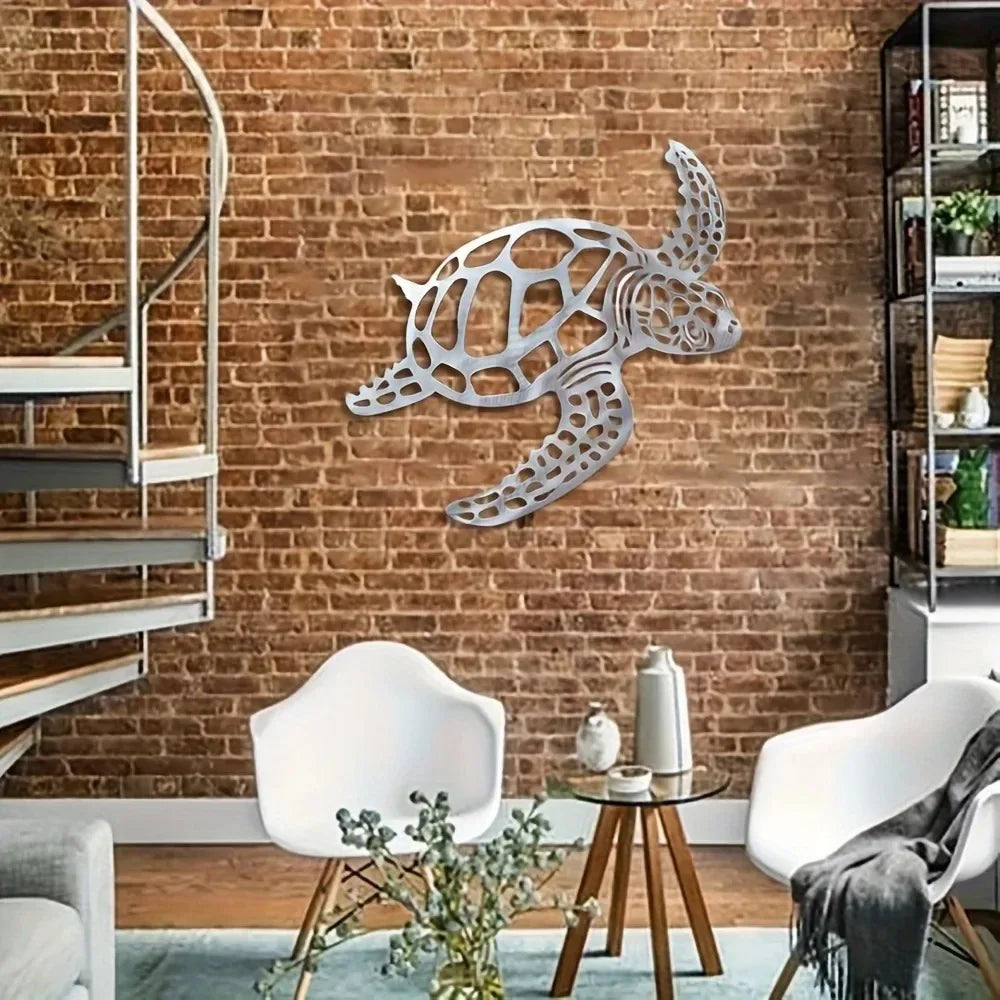 A silver metal sea turtle wall art decoration mounted on a brick wall with white chairs and wooden furniture.