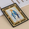 A framed Catholic icon depicting the Archangel St. Michael in blue and white robes with a golden ornate frame.