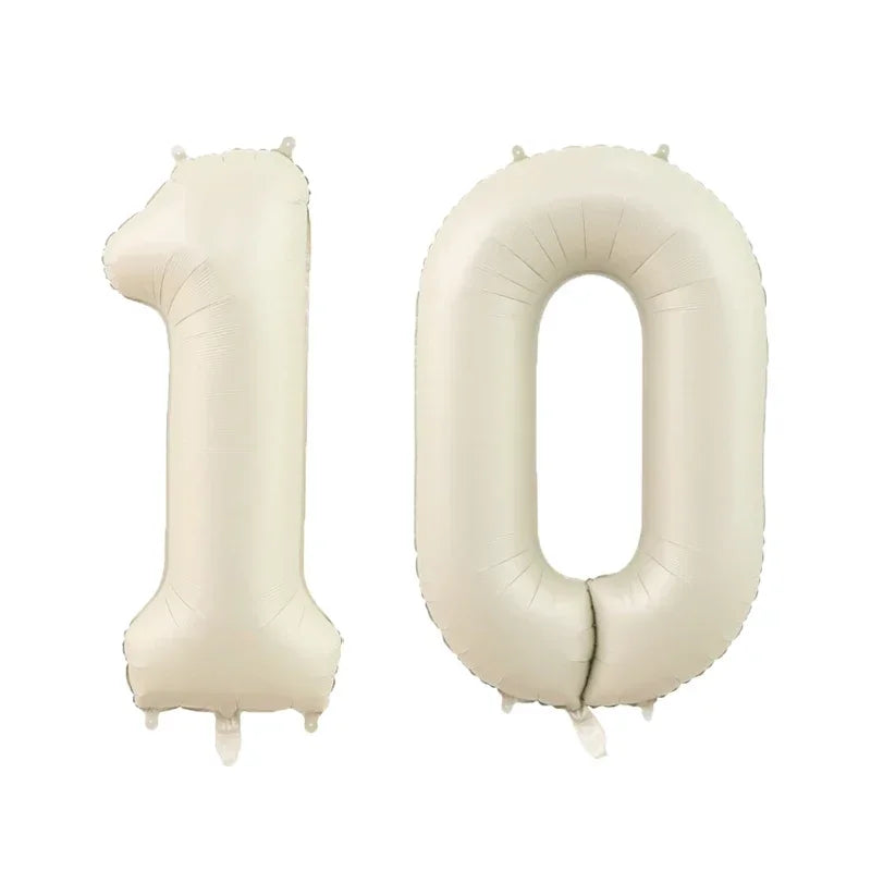 A pair of beige helium foil number balloons shaped like the digits 1 and 0.