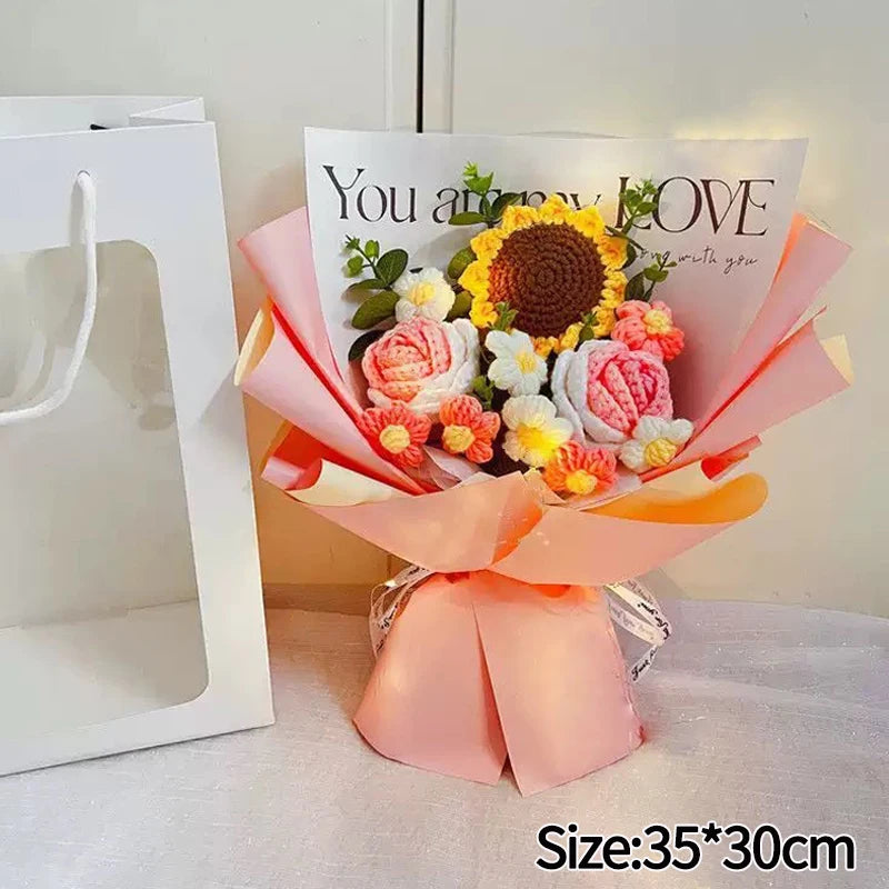 A bouquet of handmade crochet flowers in shades of yellow, pink, and white, wrapped in peach-colored paper.