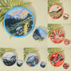 A collection of round handheld cooling fans in various colors and designs set against a light background.