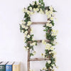 A rustic wooden ladder decorated with a green silk rose vine garland for wedding and home decor