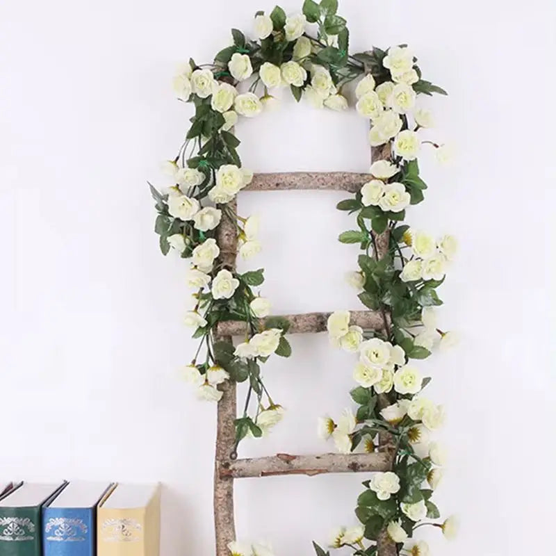 A rustic wooden ladder decorated with a green silk rose vine garland for wedding and home decor