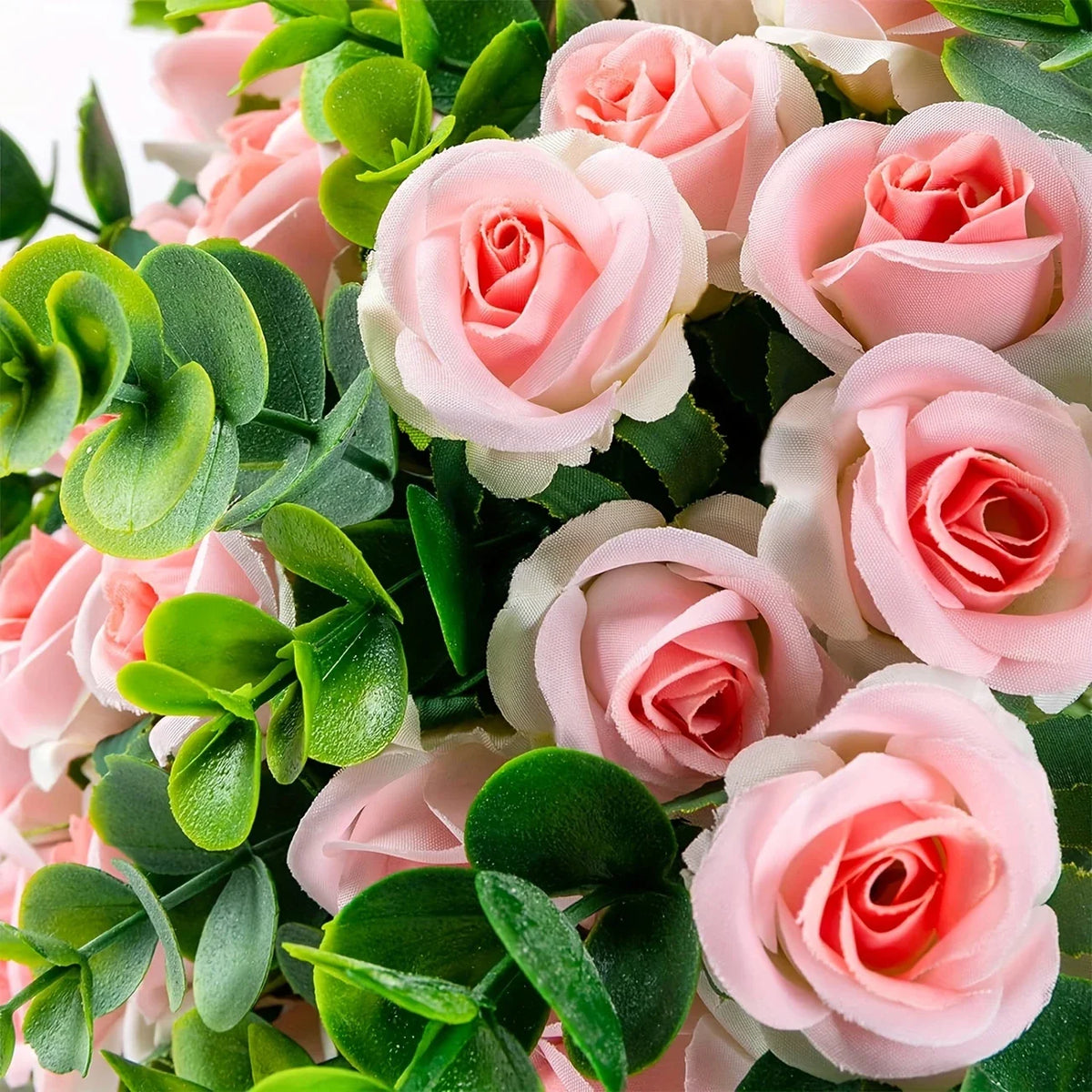 A bouquet of pink roses and green eucalyptus leaves for wedding or home decor.