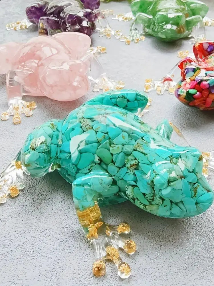 A vibrant turquoise crystal frog resin craft decoration resting on a gray surface.