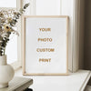 A framed custom photo print with gold text on a white background displayed next to dried floral branches.