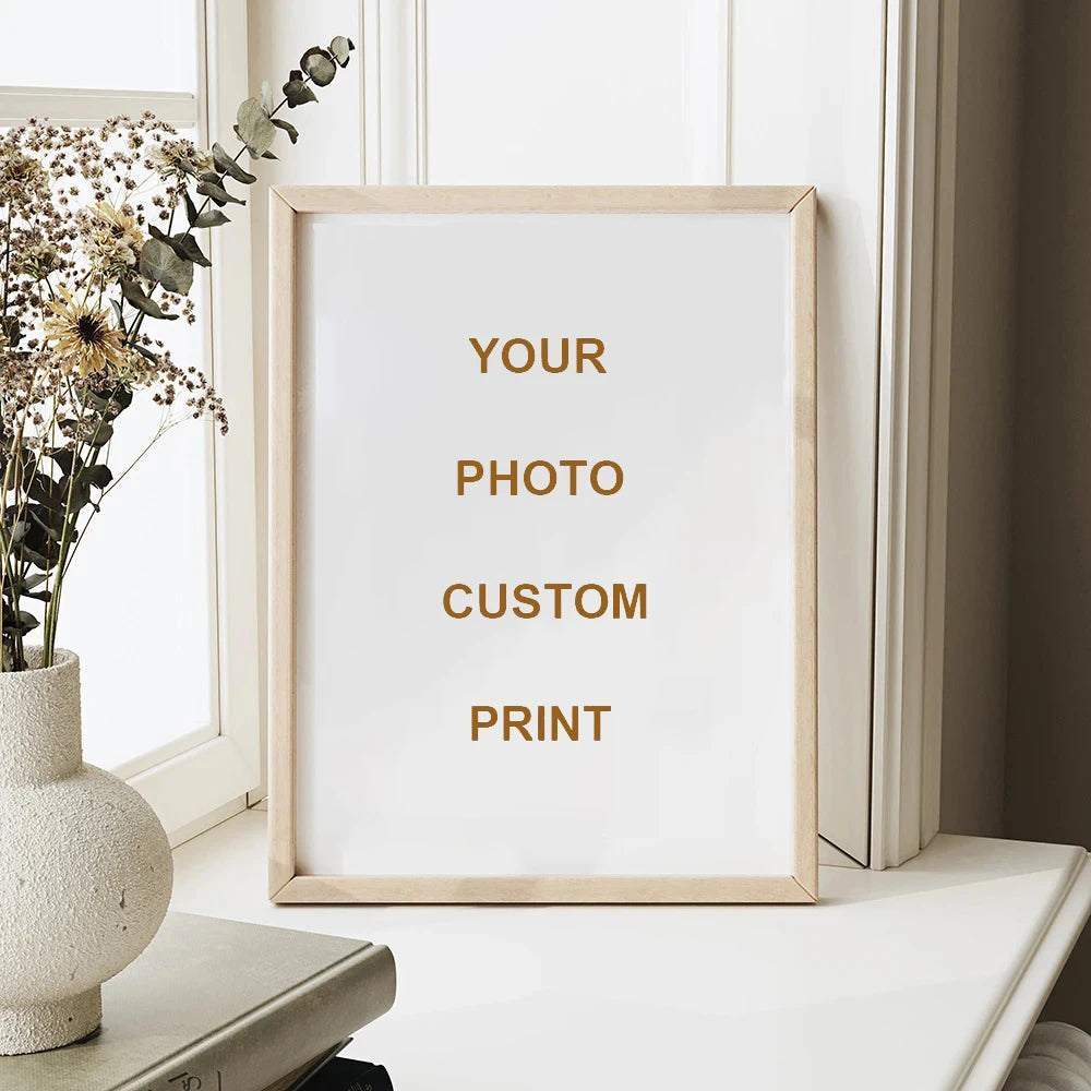 A framed custom photo print with gold text on a white background displayed next to dried floral branches.