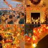A close-up of warm orange maple leaf LED string lights decorating a fireplace mantel and a table setting.