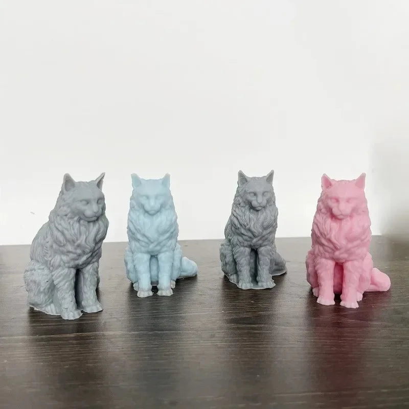 A row of four silicone cat molds in various shades of gray, blue, and pink are displayed on a dark wooden surface.