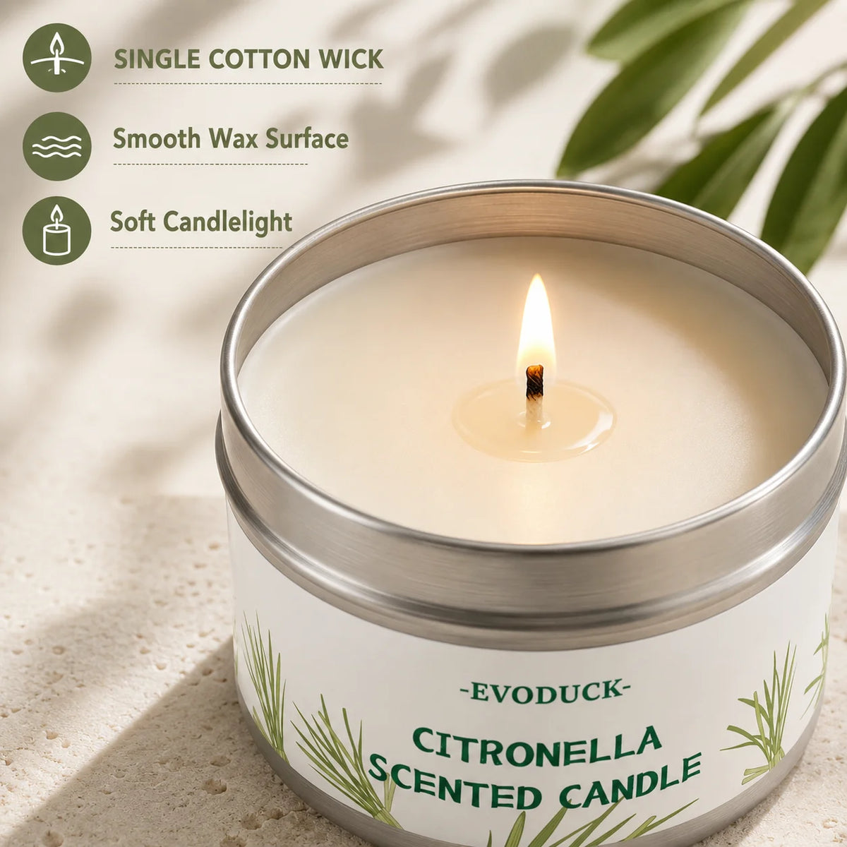 A jar of Citronella scented candle with a lit wick, set against a light background.