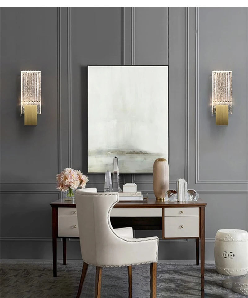 Modern bubble crystal LED wall sconces mounted on a gray wall above a wooden desk.