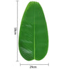 A single large, vibrant green tropical banana leaf used as a coaster or table protector.