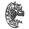 A black vintage vinyl record wall clock with text reading The Kitchen is the Heart of the Home
