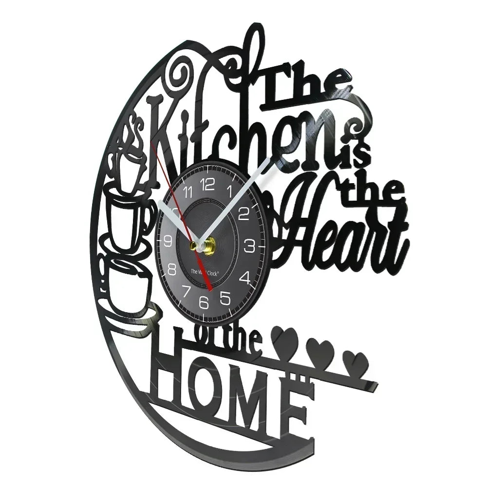 A black vintage vinyl record wall clock with text reading The Kitchen is the Heart of the Home