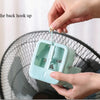Hands are hanging the back hook onto a portable ice-cooling floor fan.