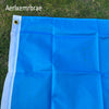 A bright blue polyester flag of the Guatemala National Flag laid out on green grass.