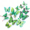 A set of twelve vibrant green and blue magnetic butterfly wall decor pieces.