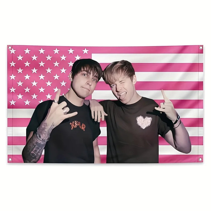 A pink American flag tapestry featuring stars and stripes with two people posing.
