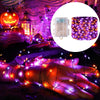 A hand is illuminated by purple and orange LED string lights, used for outdoor Halloween decor.