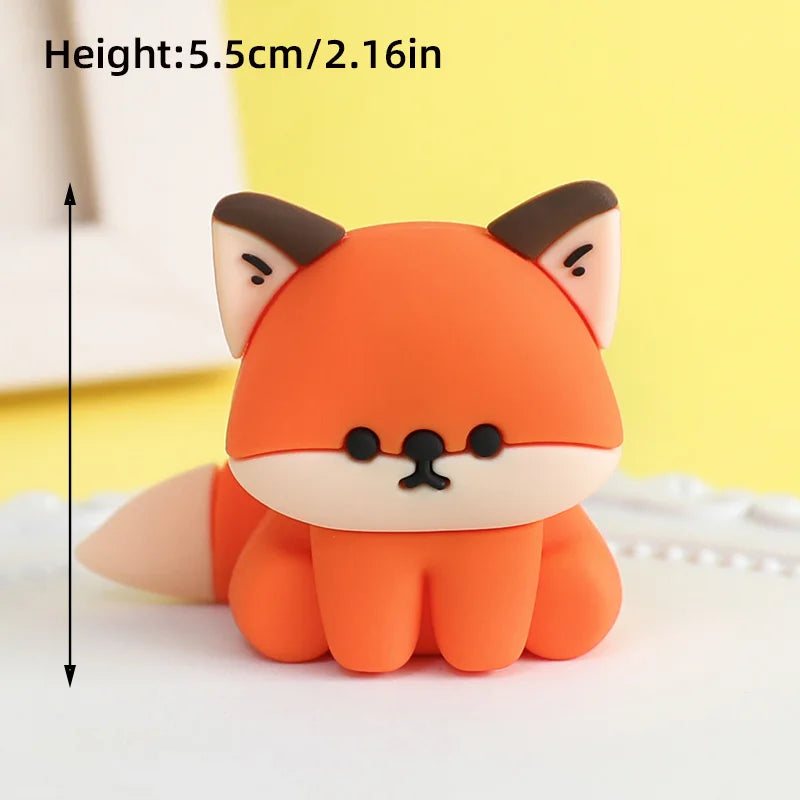 An orange fox-shaped cake topper with black accents, displayed on a white surface.