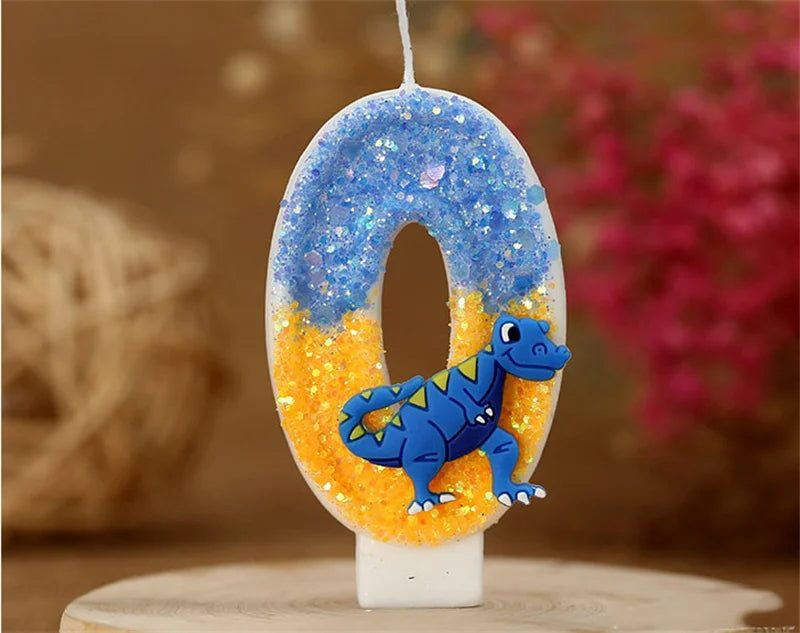 A birthday candle shaped like the number 0, decorated with blue glitter and an orange dinosaur figure.