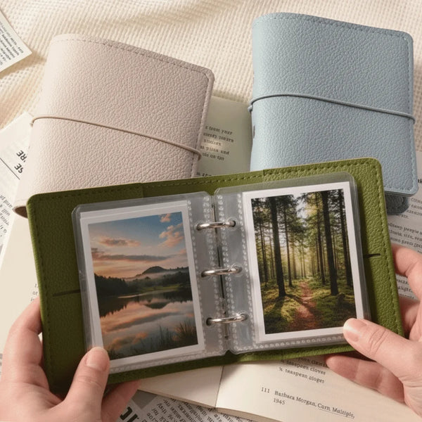 Un album photo en faux cuir vert ouvert, montrant plusieurs photos et à côté d'une couverture en cuir bleu clair.