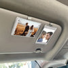A car sunshade photo frame with a magnetic visor clip holder displaying two people.