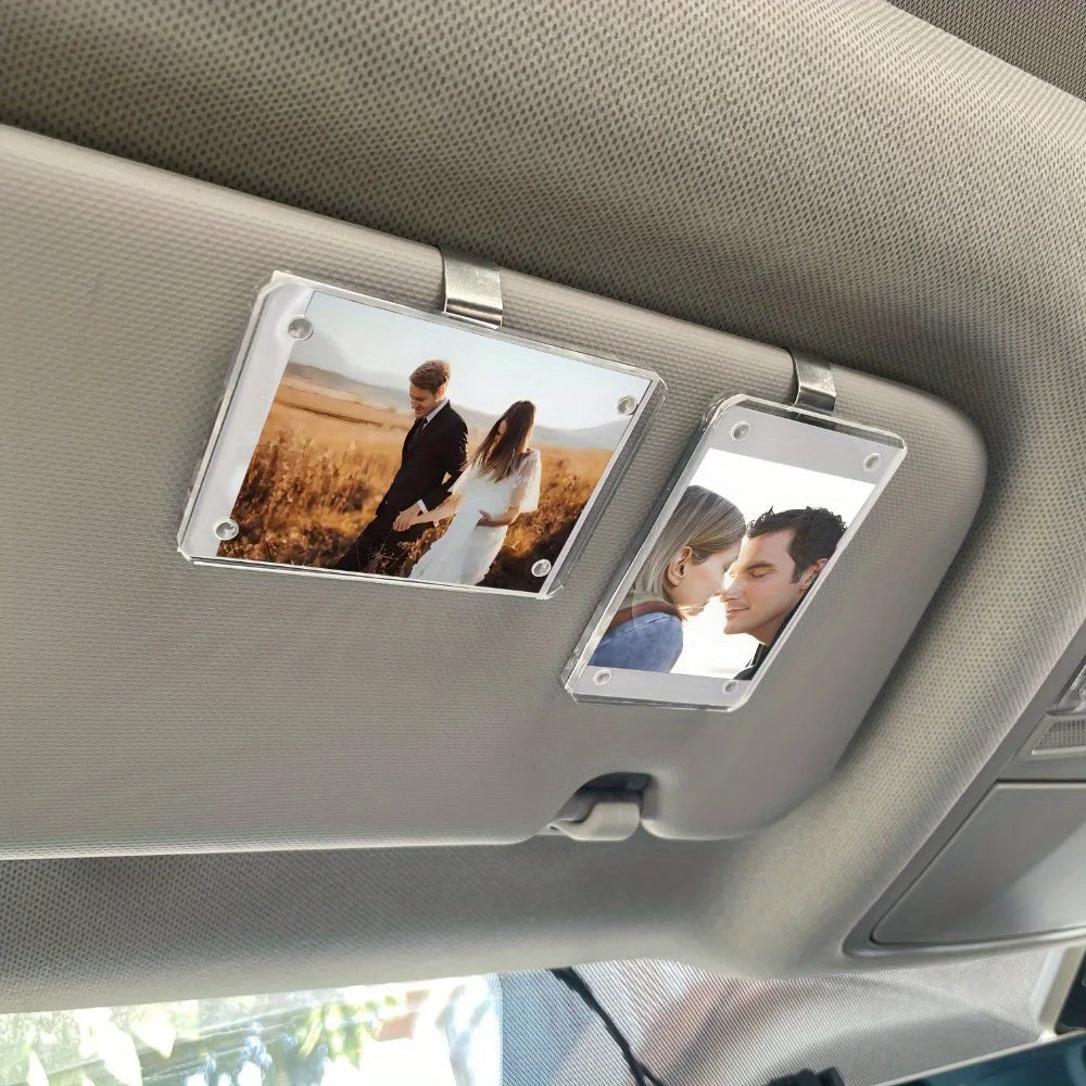 A car sunshade photo frame with a magnetic visor clip holder displaying two people.