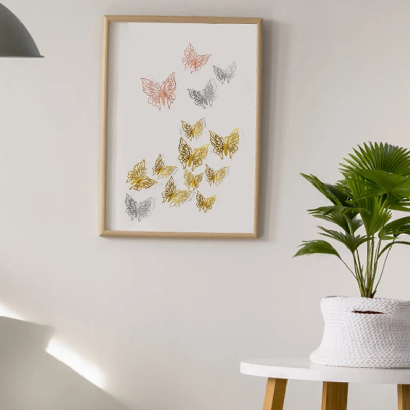 A framed watercolor illustration of various colored butterflies on a white wall above a potted green plant.