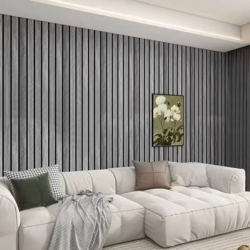 A modern living room featuring a gray vertical wood grain wallpaper and a white sectional sofa.