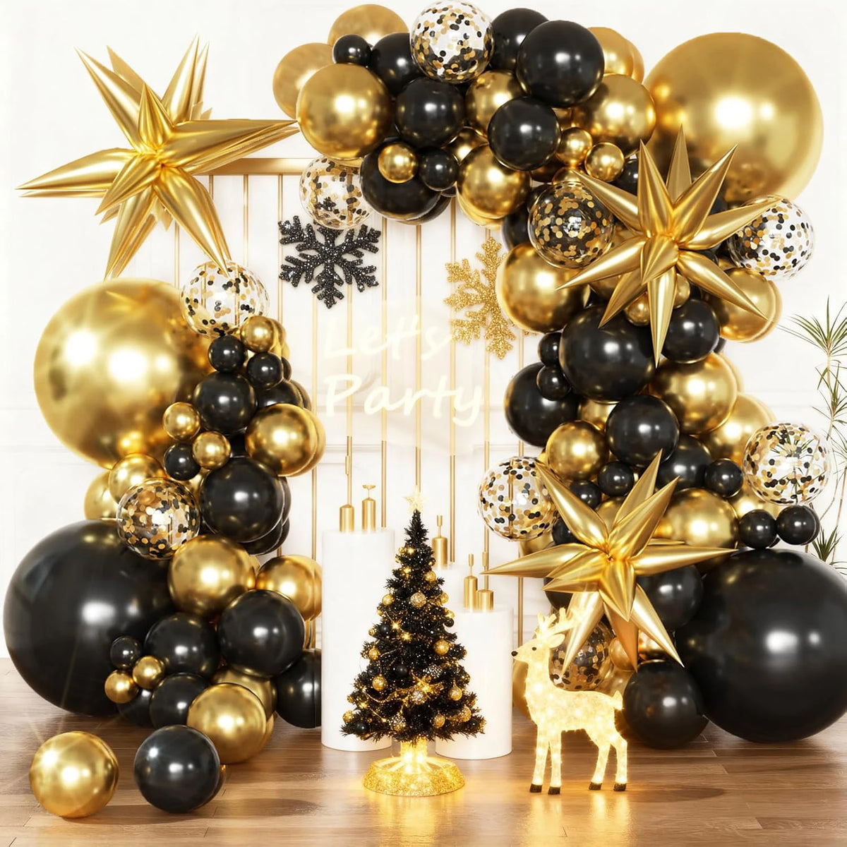 A balloon garland arch featuring black and gold balloons, stars, and a Christmas tree decoration.