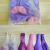 A collection of elegant pink and purple balloon shades and accessories laid out on a wooden surface.