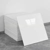 A stack of white self-adhesive marble tile stickers on a gray surface.