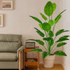 A large artificial tree with lush green leaves in a white pot displayed indoors.