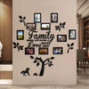 A wall decorated with various framed photos and silhouette tree designs, featuring the text Family Where Life Begins & Love N