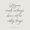 A black script Bible verse on a light gray background reads Set your minds on things above not on earthly things from Colossi