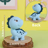 Set de topper de pastel de dinosaurio azul claro con una figura de dinosaurio de pie y una vista circular de la parte trasera