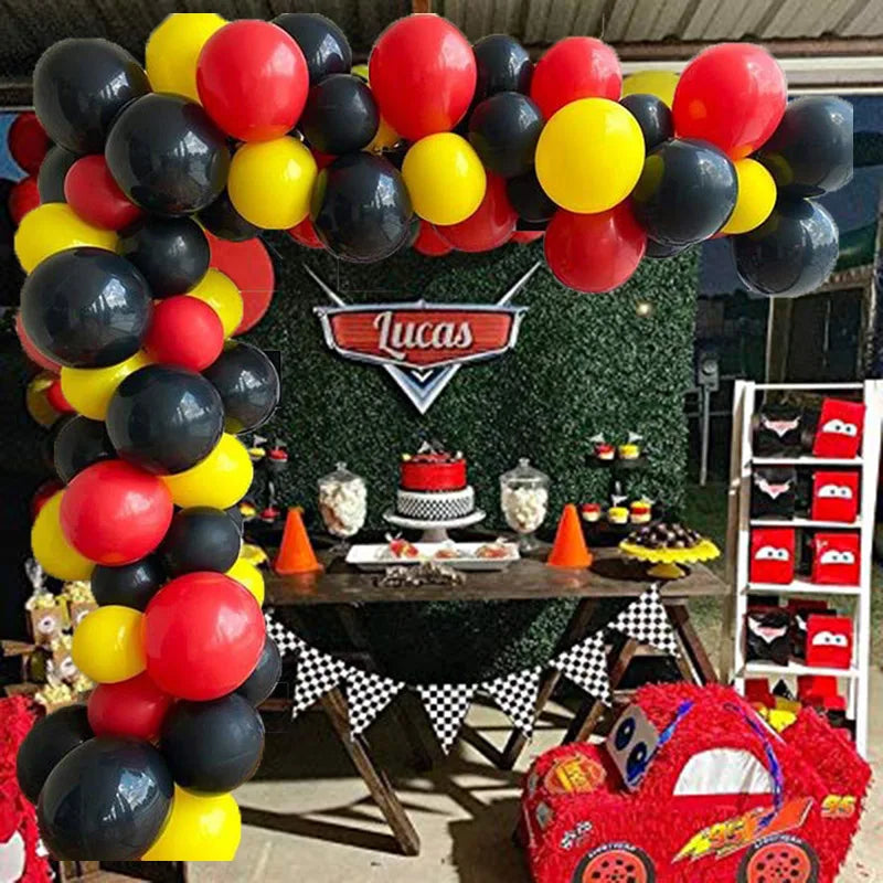 Guirlande de ballons rouge, jaune et noir disposés en décoration.