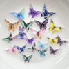 A collection of thirty colorful resin butterfly embellishments in various shades of blue, purple, and yellow scattered on a w