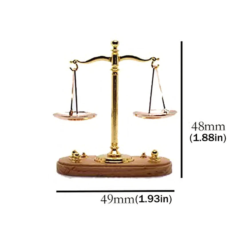 A vintage miniature balance scale with a brass frame and wooden base, used for decor.