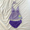 Purple and white striped sleeveless top with a tie detail laid out on a white cloth.