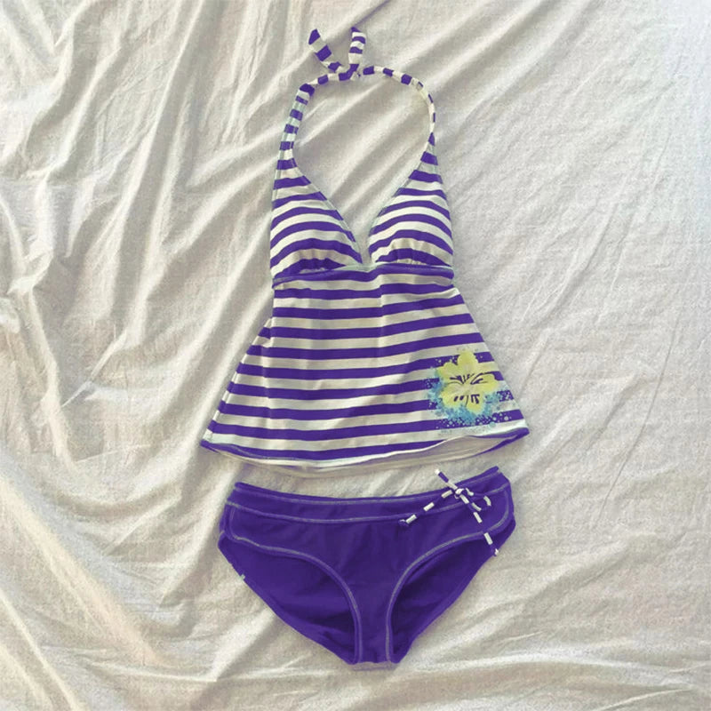 Purple and white striped sleeveless top with a tie detail laid out on a white cloth.