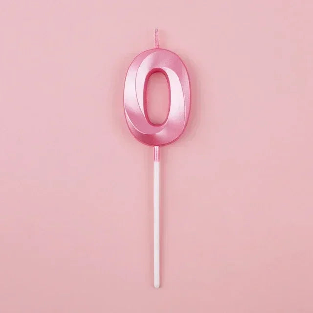 A pink number zero candle on a white stick against a light pink background.