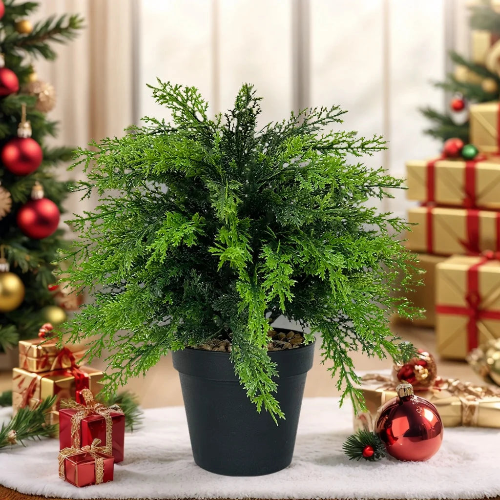 Artificial cypress topiary with green faux cedar foliage potted in a black container surrounded by wrapped gifts